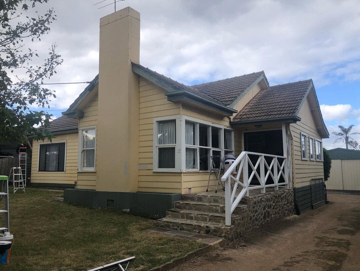 Tired 1950s weatherboard cottage brought back to life in a crisp coastal white with charcoal trim. — before